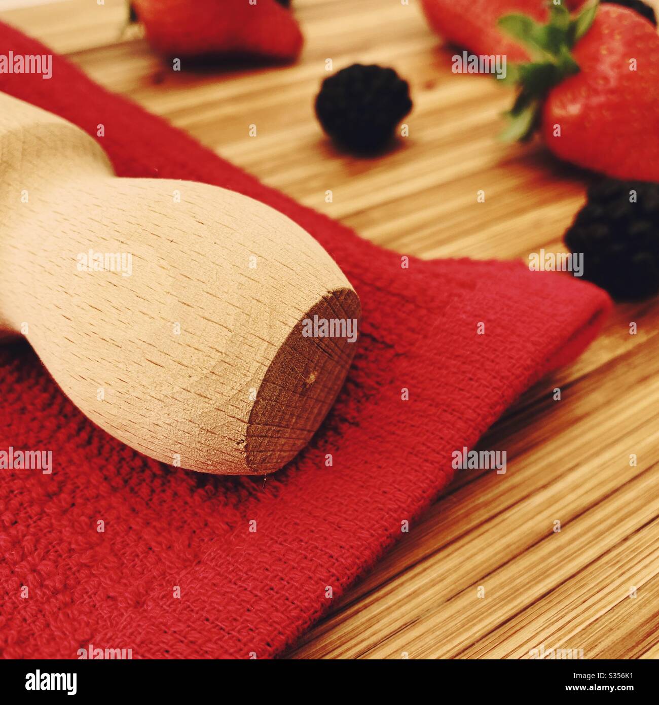Strawberries and blackberries on a wooden kitchen counter. Ingredients for baking a summer berry, strawberry and blackberry pie. - Smartphone Captured Stock Image