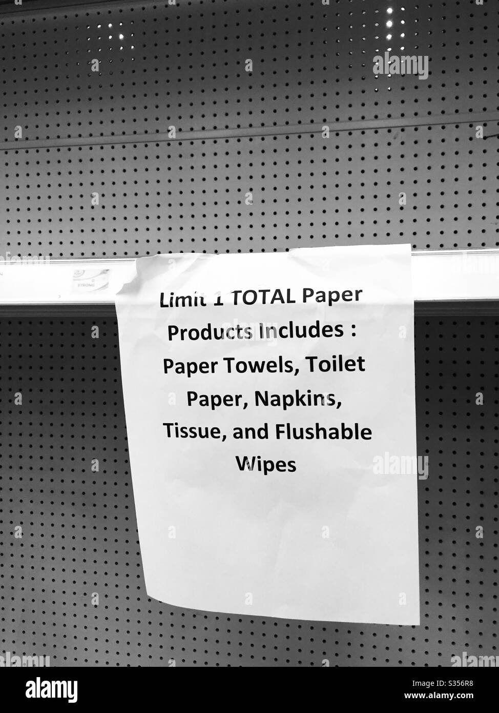 Empty grocery store shelves, previously stocked with paper towels, toilet paper and tissue, with limit of one per person. Galveston Texas April 11, 2020 Stock Photo