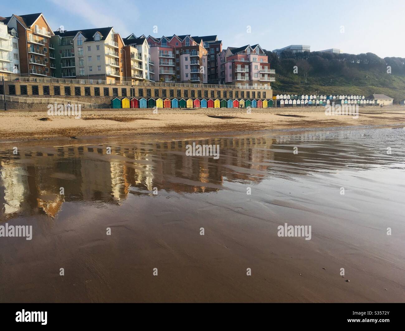 Beach huts and reflections in the sand at low tide on Boscombe Beach, Dorset, UK Stock Photo