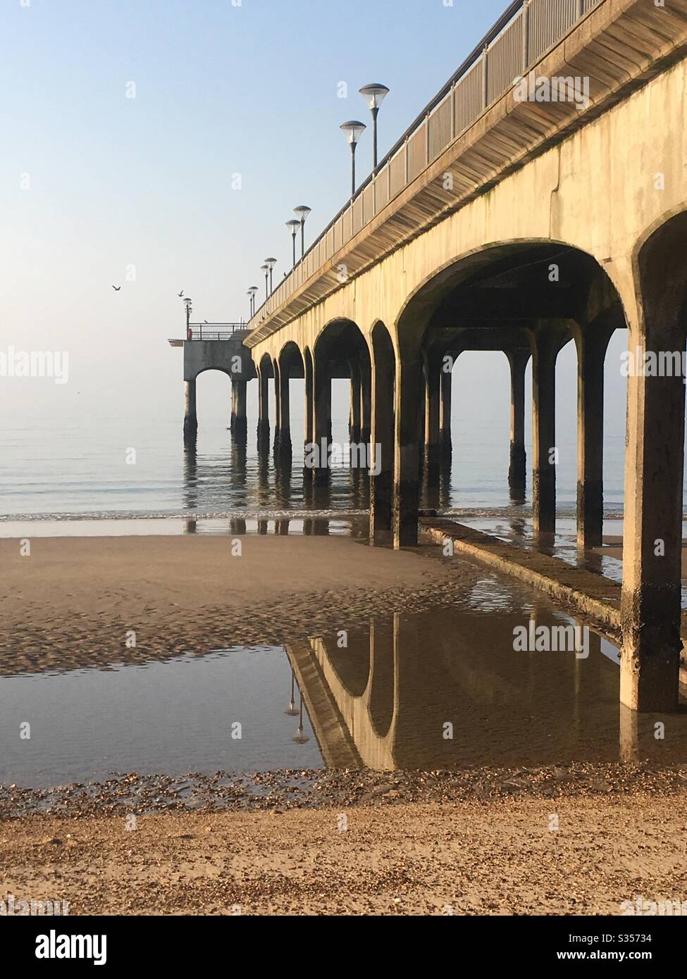 Reflections in the sand at low tide of Boscombe Pier, Bournemouth, Dorset, UK Stock Photo