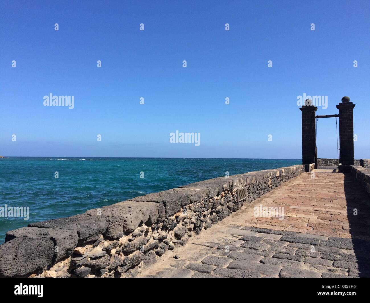 Stone walkway across the water towards the castle in Arrecife, Lanzarote, Spain. Stock Photo