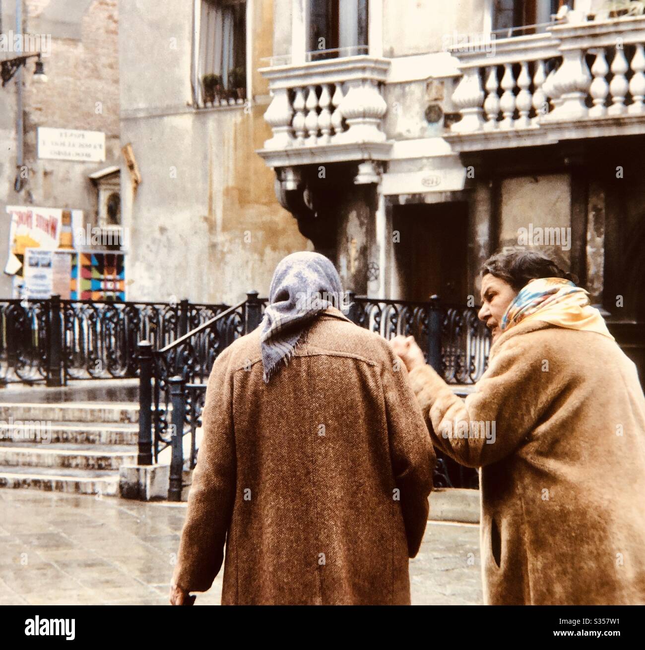 Two old women walking and talking on street Venice Italy Stock Photo