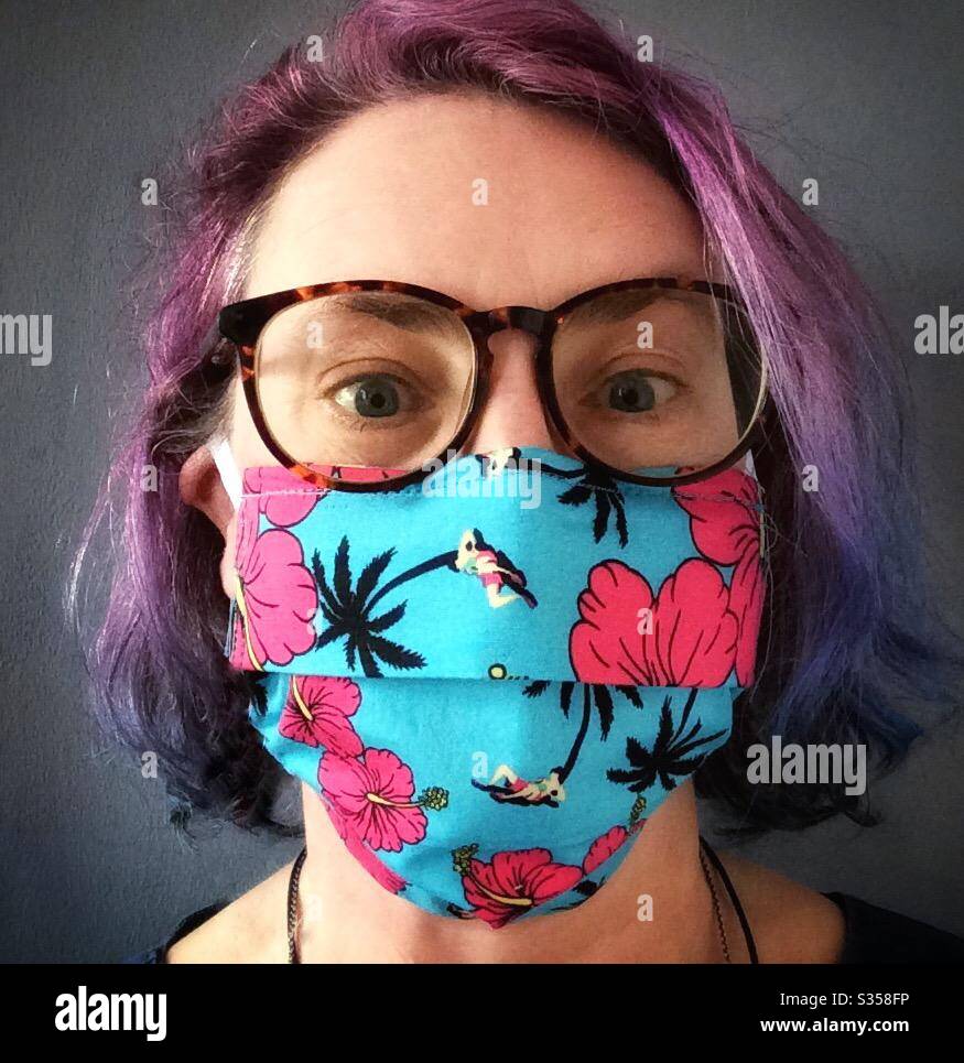 Woman wearing flamboyant and colourful face mask during Covid-19 pandemic - Smartphone Captured Stock Image