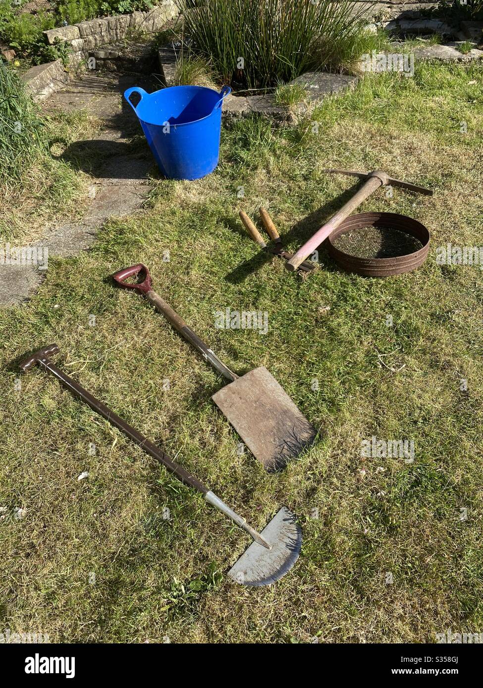 Spring is here, gardening tools on the lawn - Smartphone Captured Stock Image