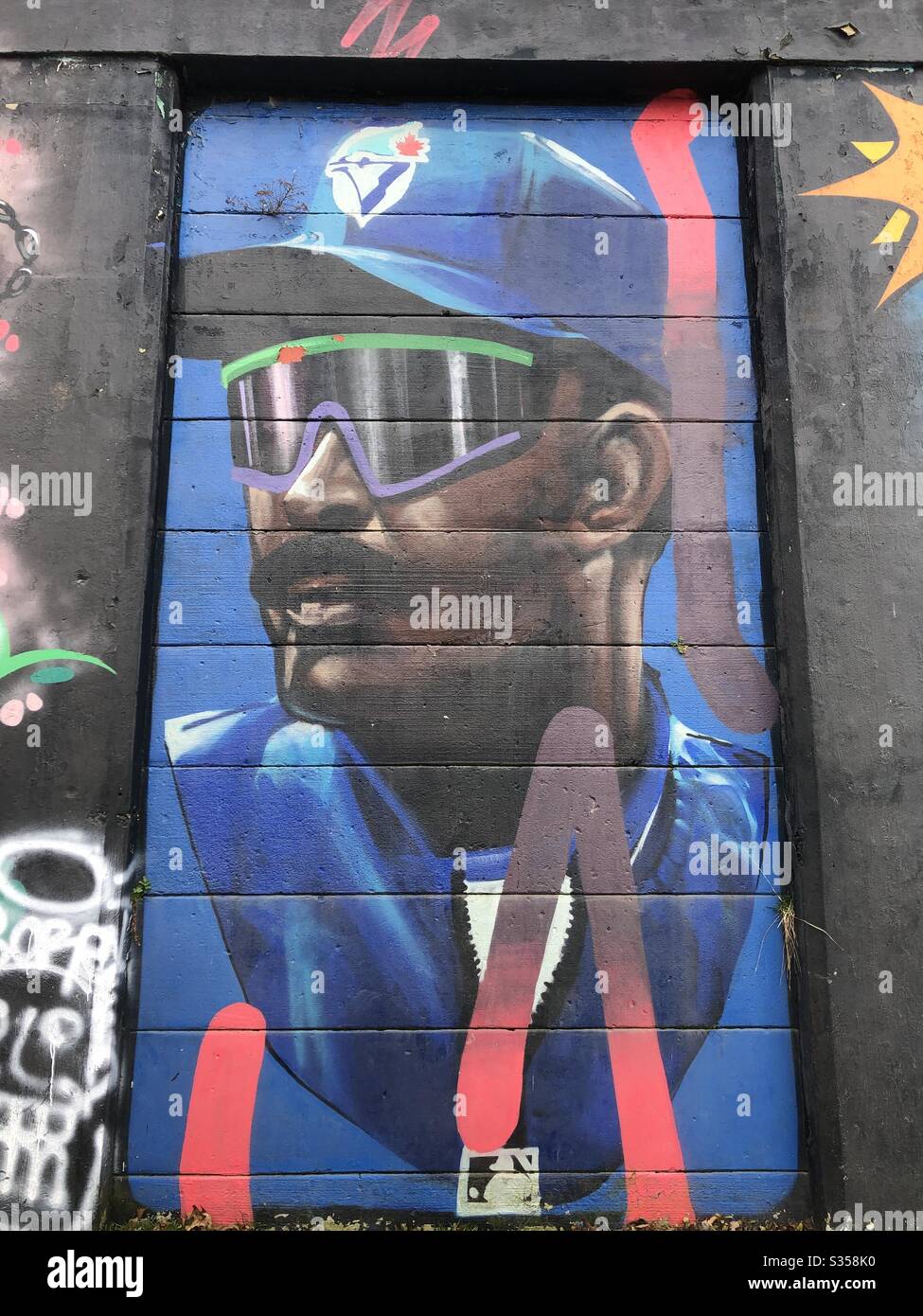 Urban street graffiti mural depicting a Toronto Blue Jay baseball player. - Smartphone Captured Stock Image
