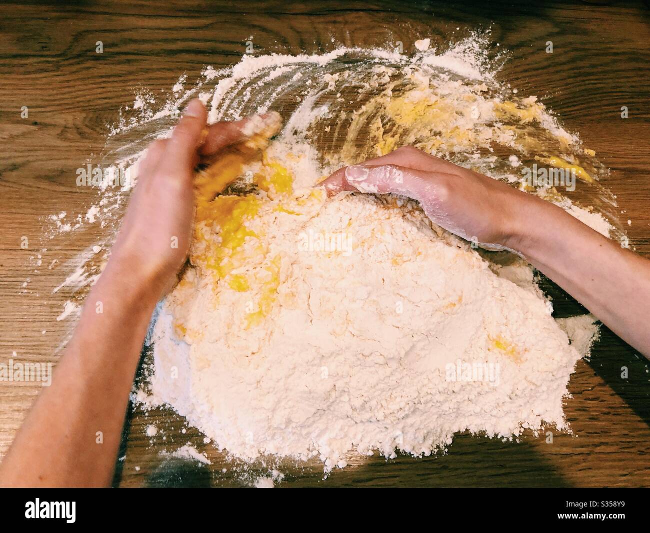 Hands mixing eggs and flour to make pasta dough Stock Photo Alamy