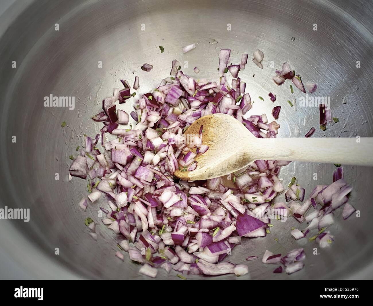 Preparing homemade salsa with red onion, lime juice and coriander in the kitchen. Freshly chopped and mixed in steel bowl. Ingredients for pineapple salsa In mixing bowl. Home recipe prepping. - Smartphone Captured Stock Image