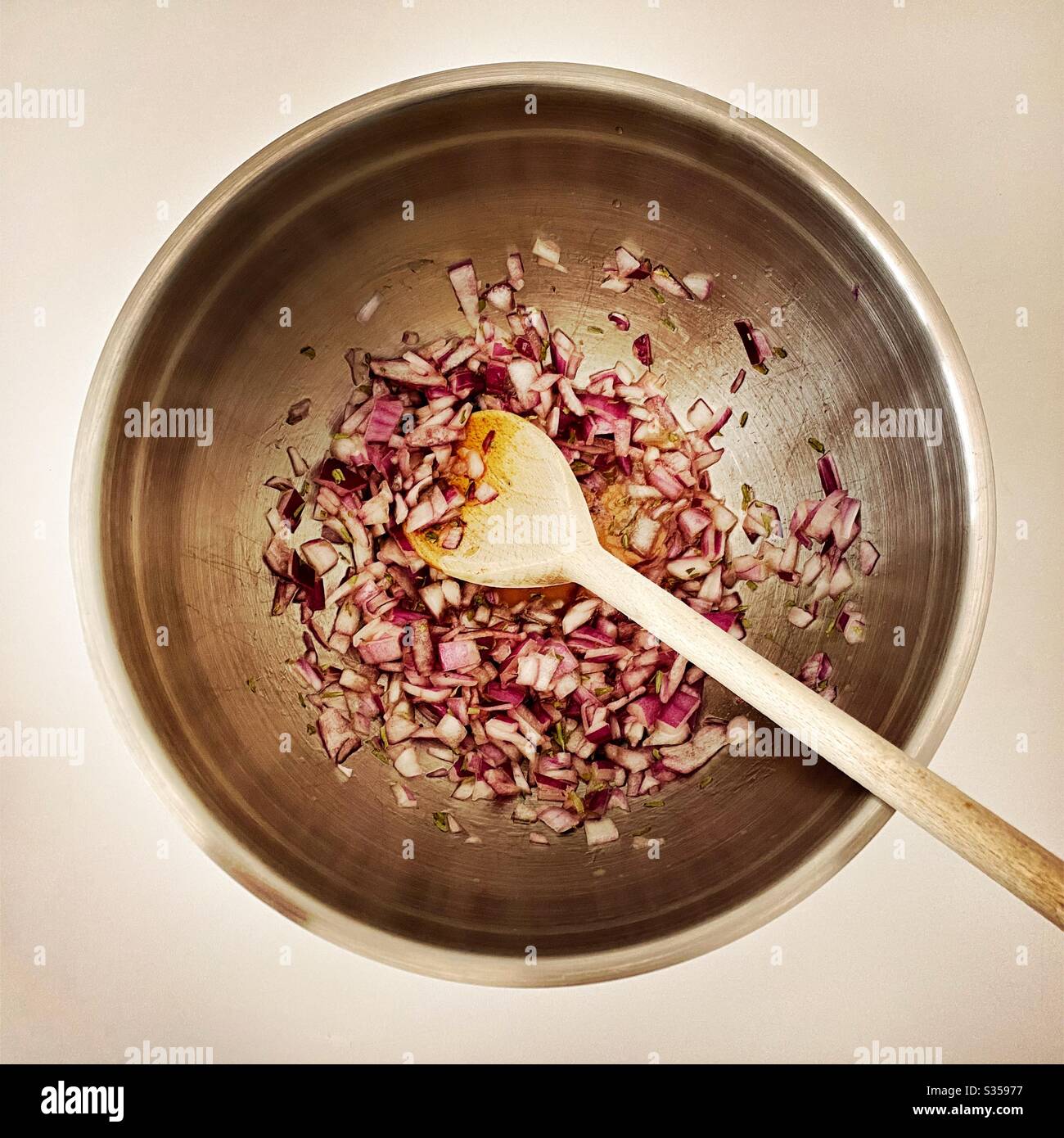 Preparing homemade salsa with red onion, lime juice and coriander in the kitchen. Freshly chopped and mixed in steel bowl. Ingredients for pineapple salsa In mixing bowl. Home recipe prepping. - Smartphone Captured Stock Image