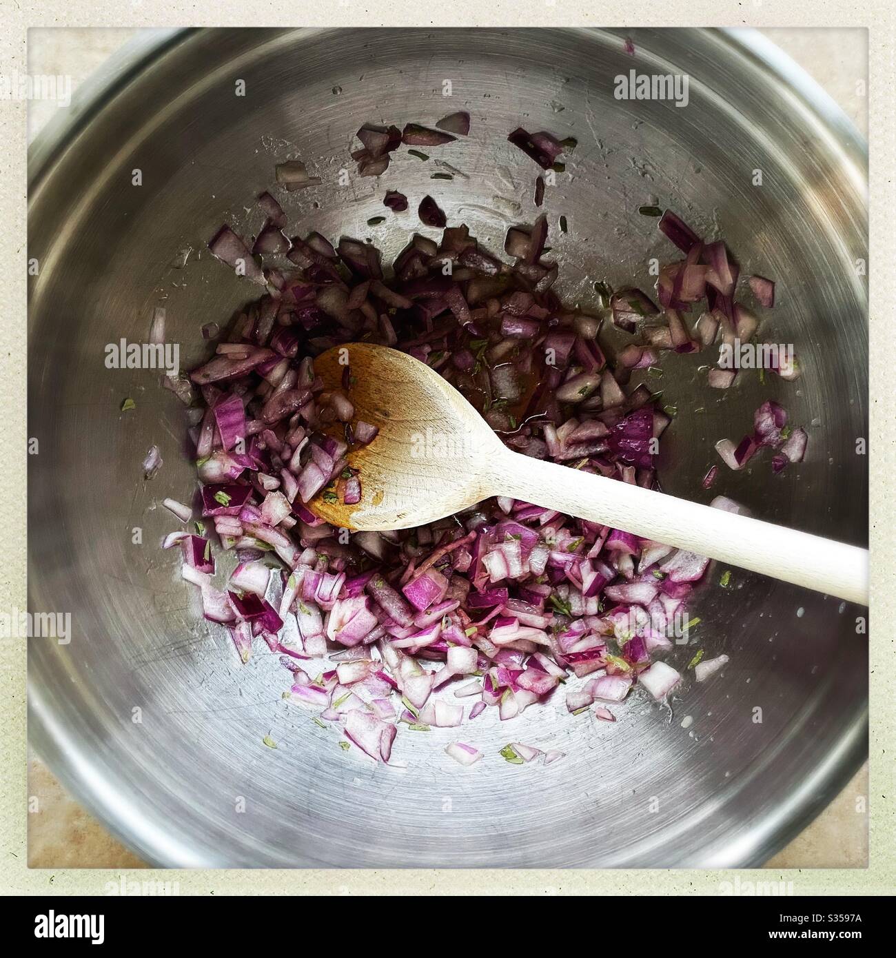 Preparing homemade salsa with red onion, lime juice and coriander in the kitchen. Freshly chopped and mixed in steel bowl. Ingredients for pineapple salsa In mixing bowl. Home recipe prepping. - Smartphone Captured Stock Image