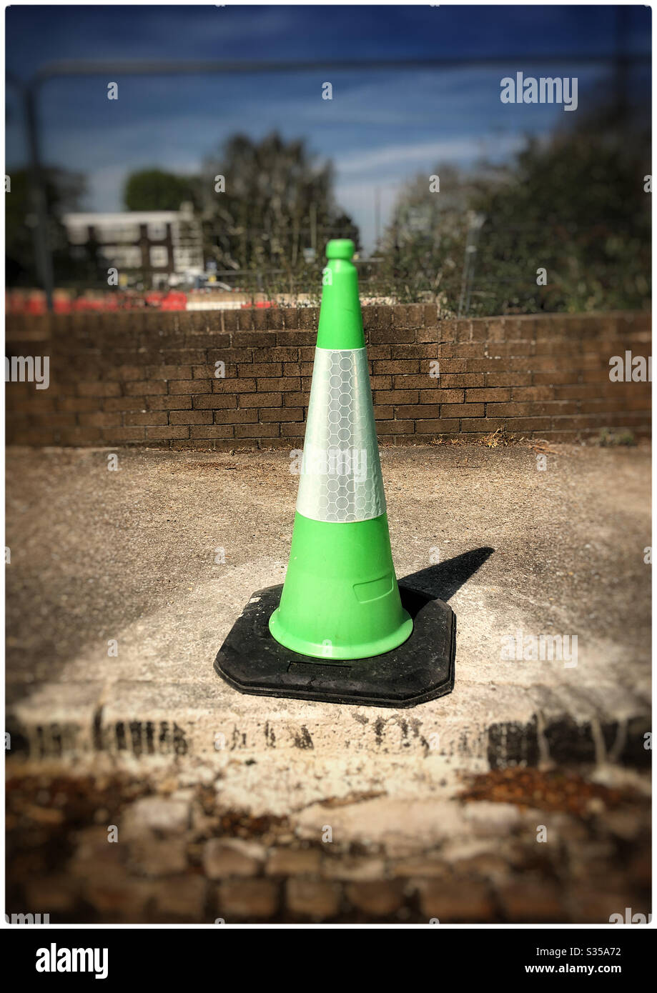 Green and white traffic cone over paint spillage - Smartphone Captured Stock Image
