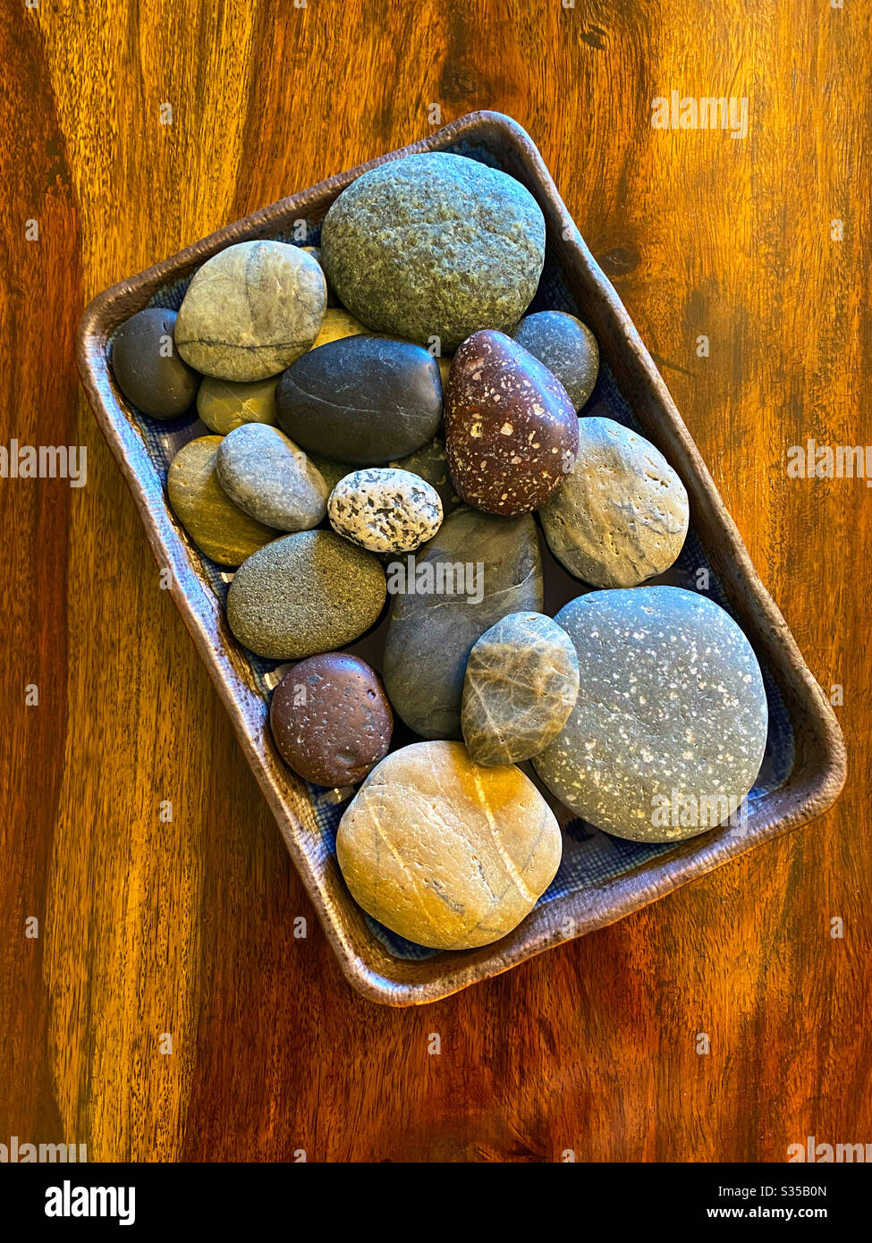 Collection of smooth stones in a ceramic tray - Smartphone Captured Stock Image