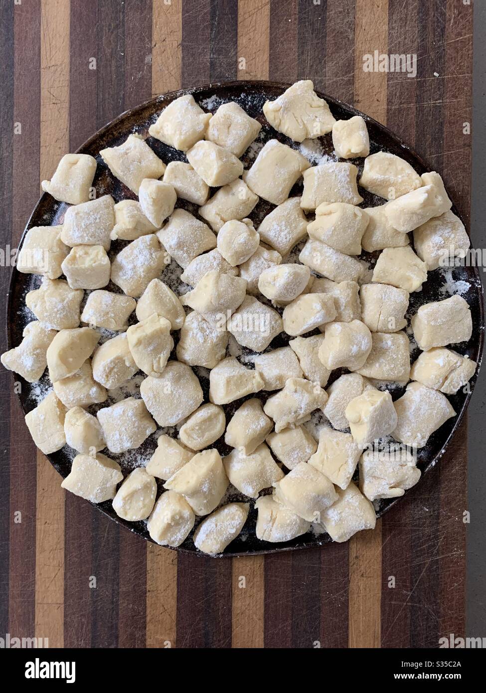 Home made potato gnocchi sitting on a pizza pan waiting to be dipped into boiling water - Smartphone Captured Stock Image