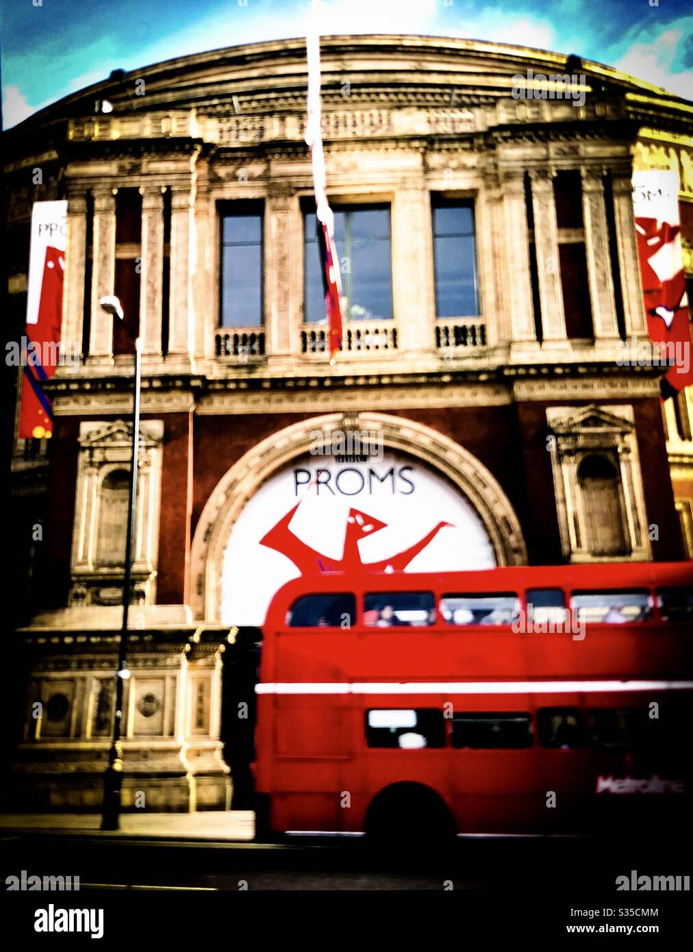 Red double Decker bus zooms past Royal Albert Hall during summer proms season - Smartphone Captured Stock Image