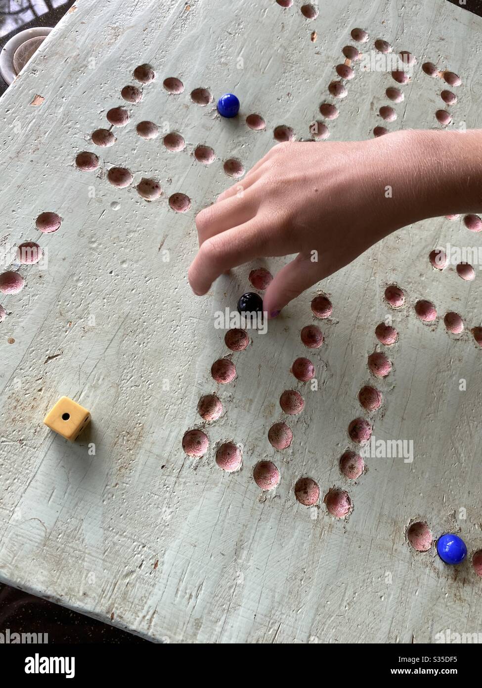 Playing the game of wahoo with board, marbles and dice - Smartphone Captured Stock Image