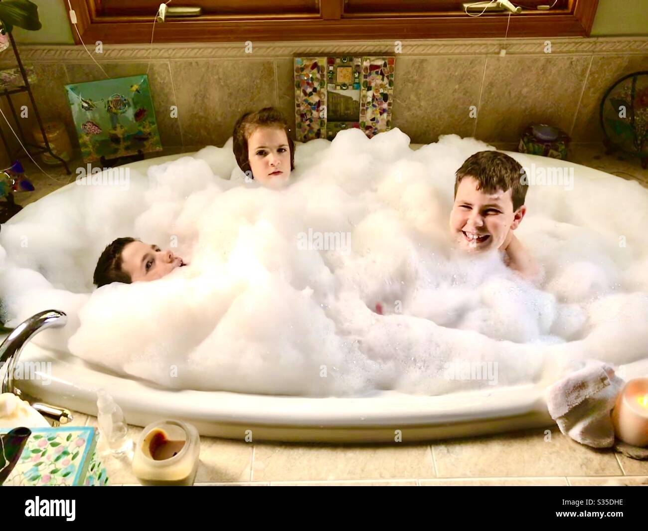 Three kids in a bubble bath Stock Photo