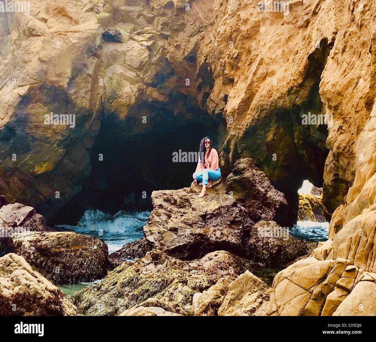 Woman sitting on rock Pfeiffer beach - Smartphone Captured Stock Image