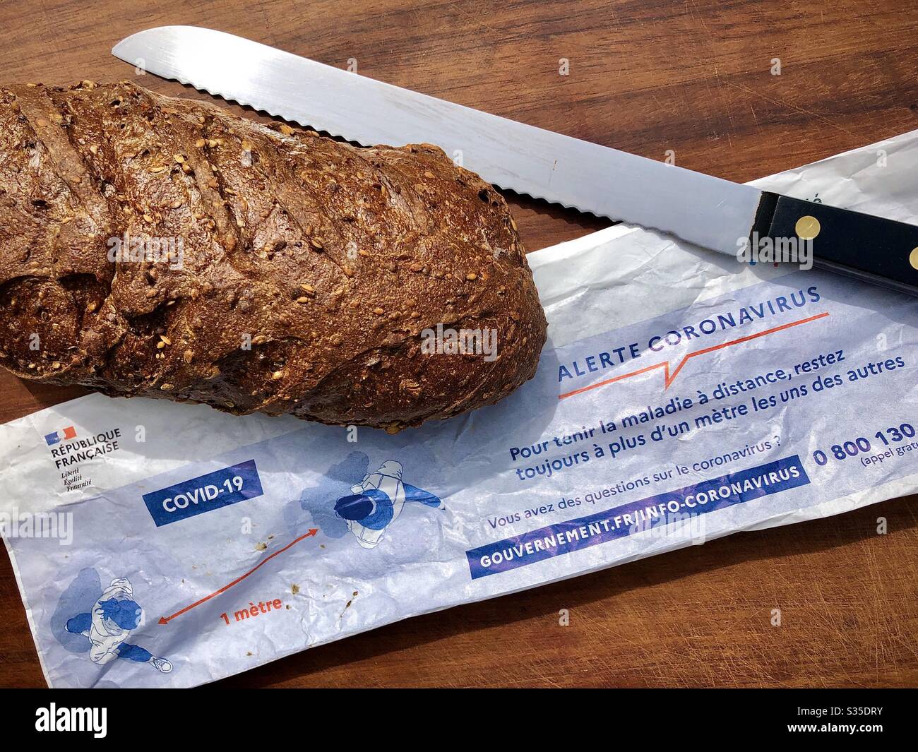 Paper bag for French bread with printed Coronavirus warning and instructions in France. Stock Photo
