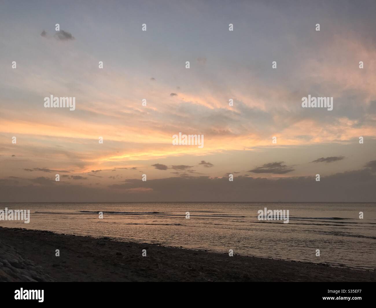 Sunset over a deserted beach. Muscat, Oman. With the lockdown due to the pandemic of Corona virus,the beaches have been empty with the exception of few people. - Smartphone Captured Stock Image