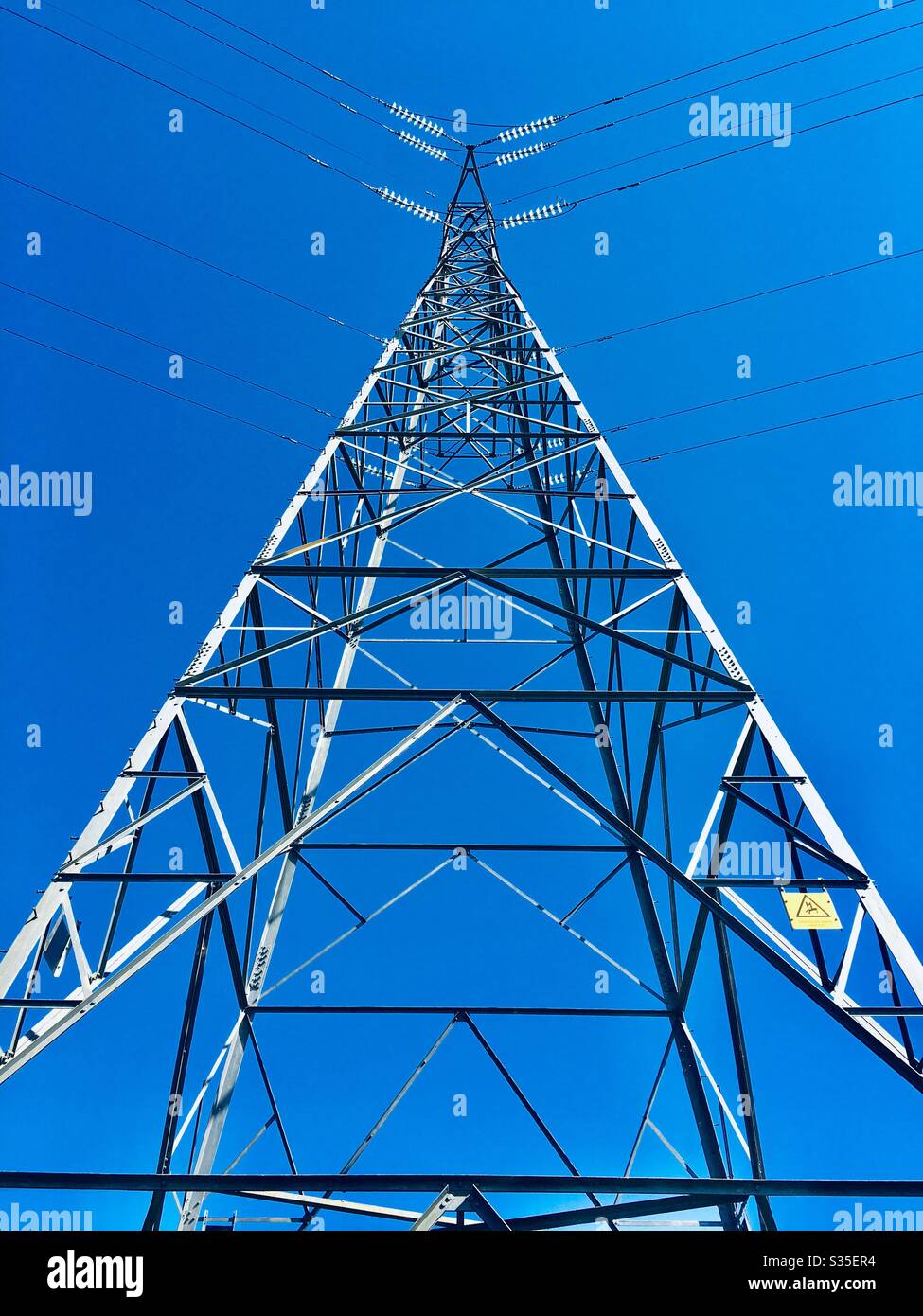 Electricity pylon against a blue sky looking up England UK GB - Smartphone Captured Stock Image