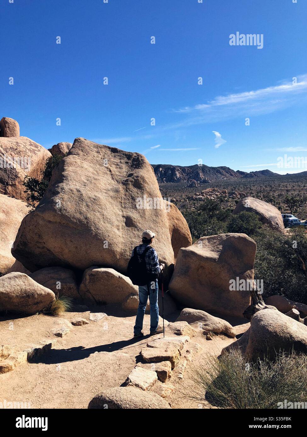 A hiker admiring rocks formations in joshua tree national park - Smartphone Captured Stock Image