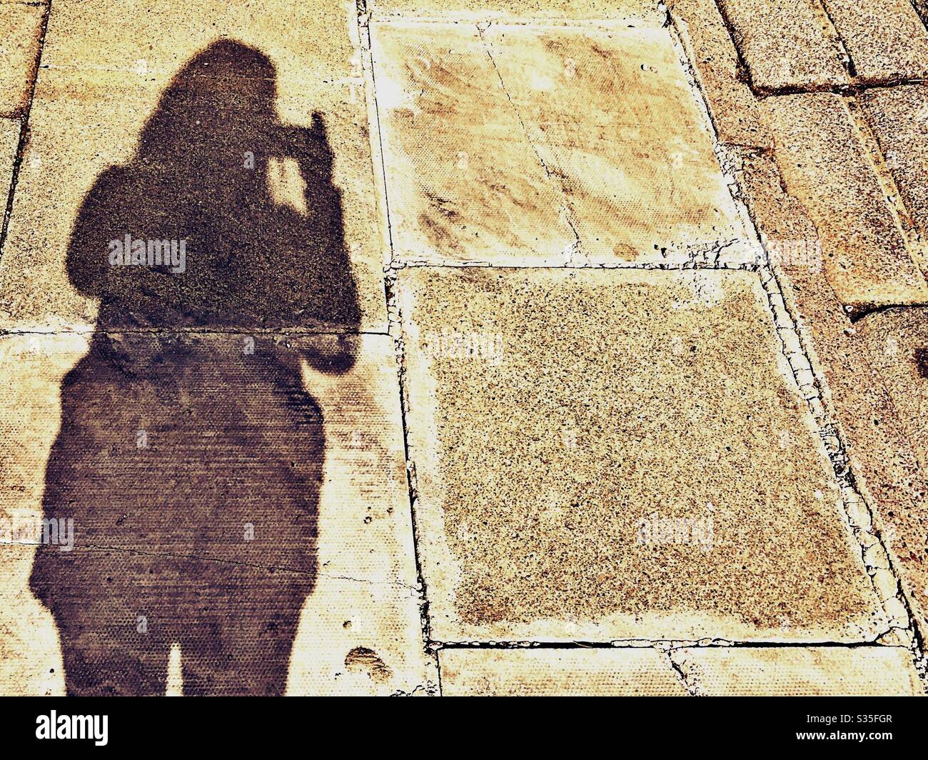 Shadow of person on pavement walking alone. Daily exercise. Social distancing self isolation - Smartphone Captured Stock Image