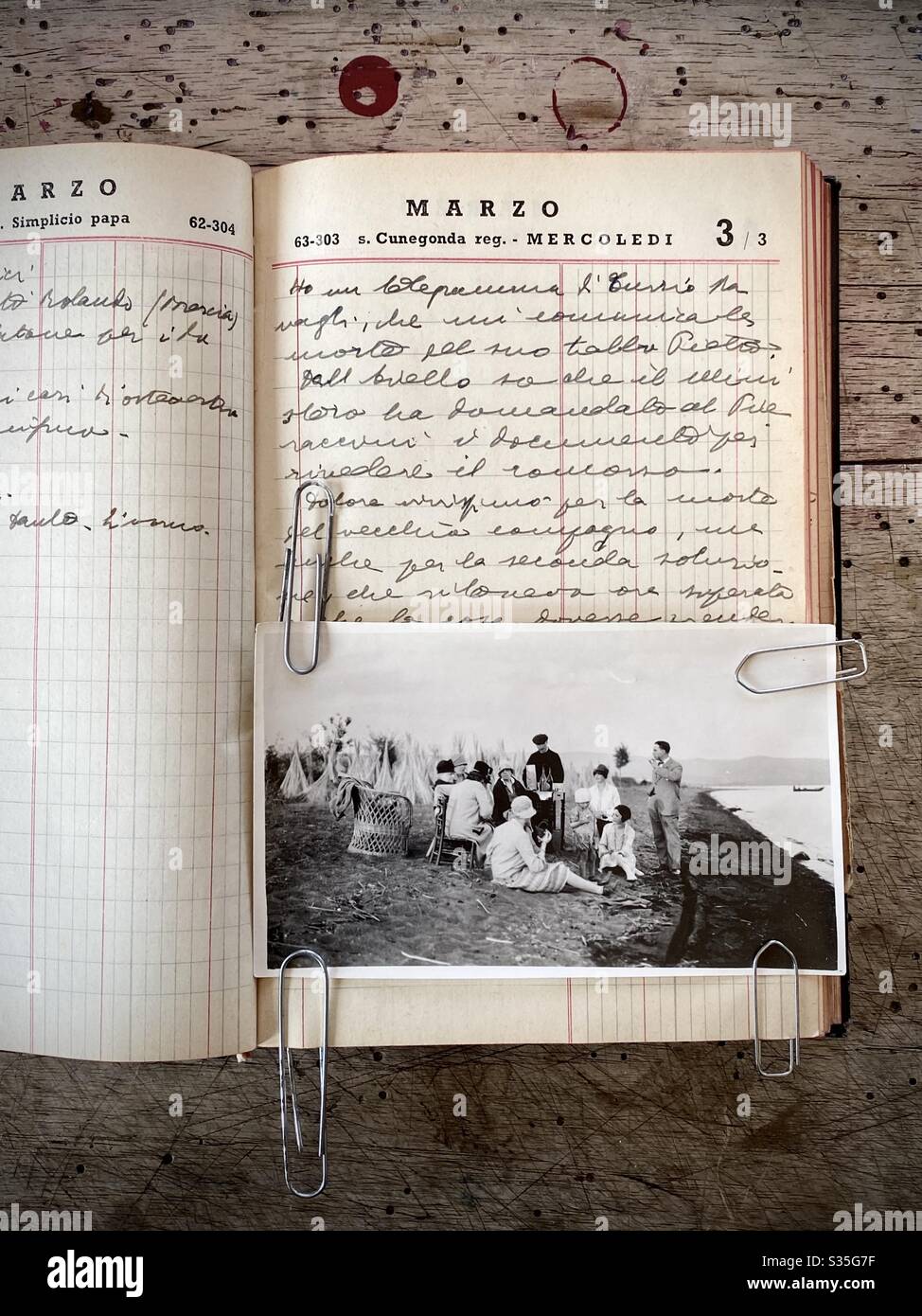 Old photo print representing a family shot displayed in a vintage notebook. Stock Photo
