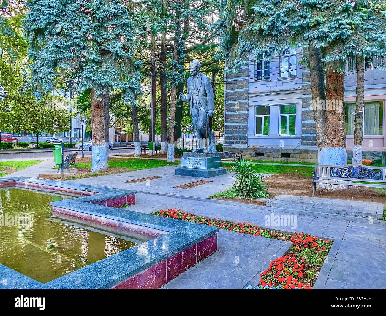 Statue of the composer Pyotr Ilyich Tchaikovsky in Borjomi, Georgia, Europe. Surrounded by a fountain, flowers and a building. - Smartphone Captured Stock Image