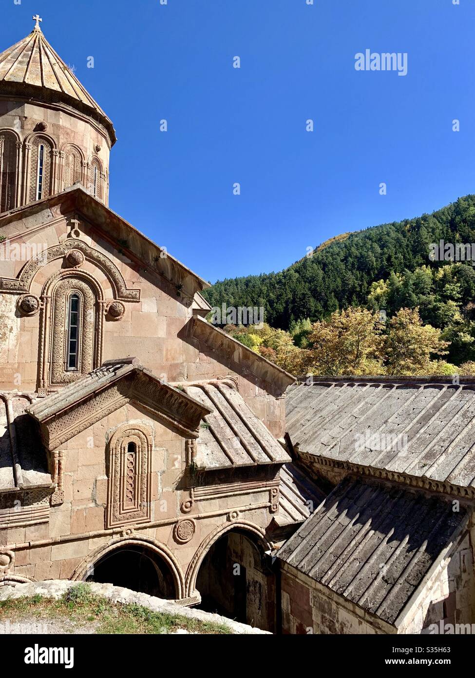A beautiful Georgian Church within the grounds of a monastery, surrounded by forests. - Smartphone Captured Stock Image
