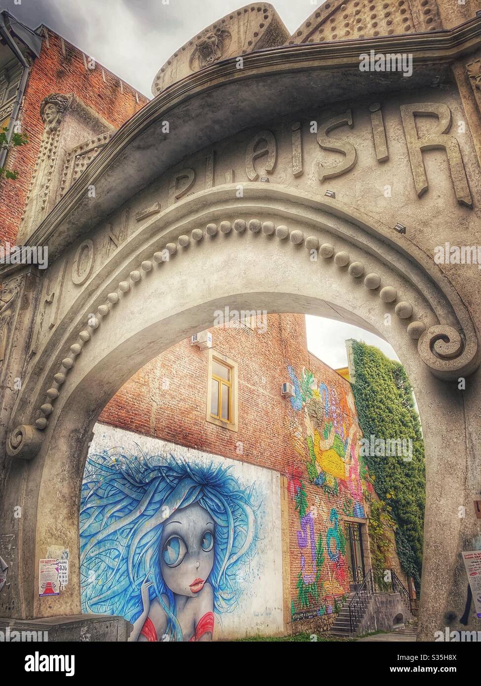 Colourful street art through an arch in Kutaisi, Georgia. - Smartphone Captured Stock Image