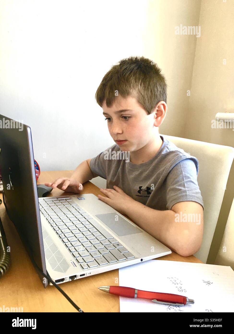Boy working at laptop during corona virus - Smartphone Captured Stock Image