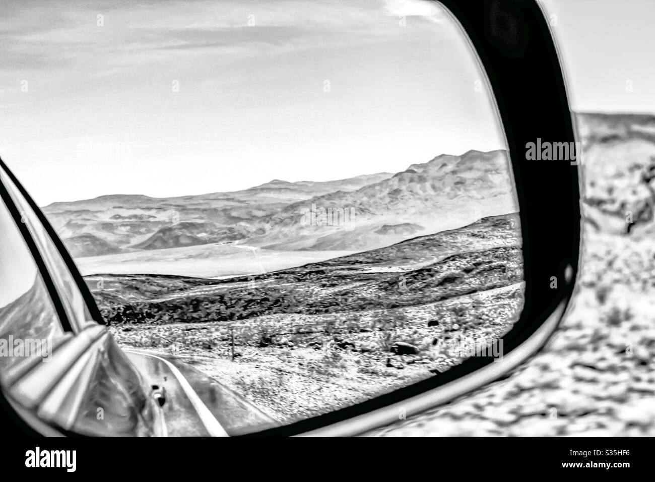 Desert landscape view from the side view mirror in black and white ...