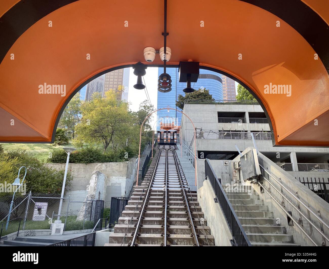 LOS ANGELES, CA, APR 2020: view through orange arch at Hill St station of Angels Flight funicular railway towards skyscrapers in Downtown Financial District. Railway closed during coronavirus pandemic - Smartphone Captured Stock Image