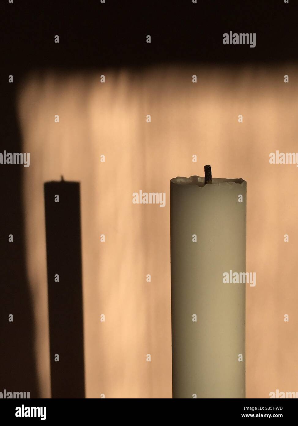 An extinguished candle and its shadow. - Smartphone Captured Stock Image