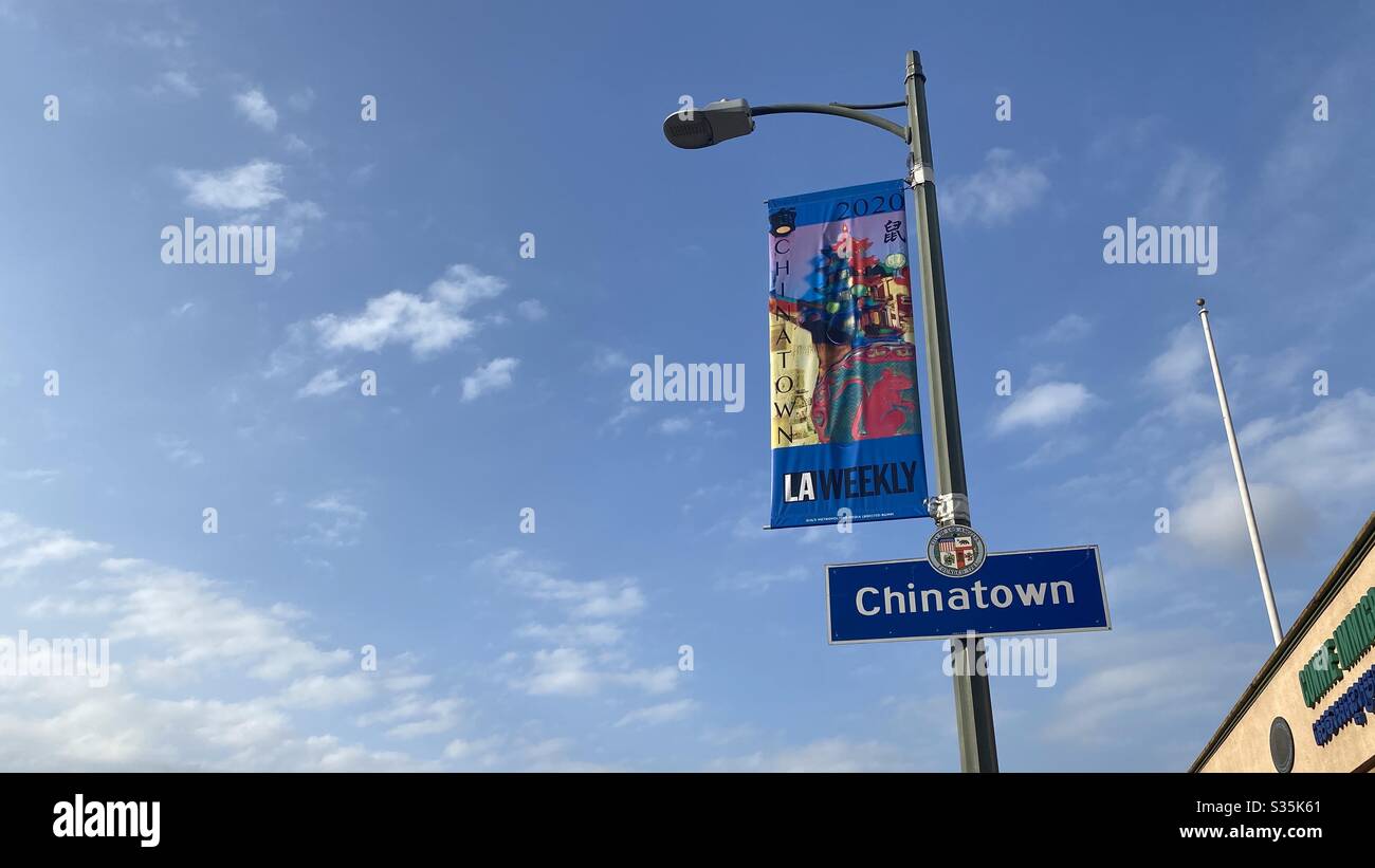 LOS ANGELES, CA, APR 2020: street sign and banner on street in China Town district of Downtown. Isolated against blue sky with clouds - Smartphone Captured Stock Image