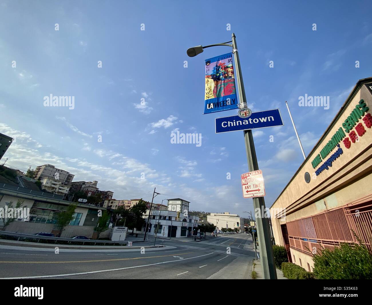 LOS ANGELES, CA, APR 2020: street sign and banner on street in China Town district of Downtown. Street view with library and retail outlets, sparse traffic during coronavirus pandemic - Smartphone Captured Stock Image