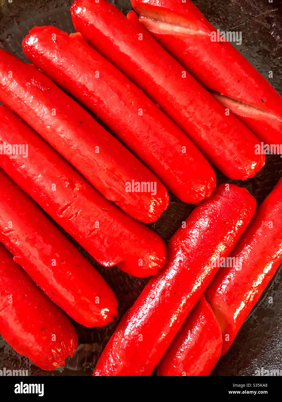 Red Filipino hotdogs cooking in a frying pan Stock Photo Alamy