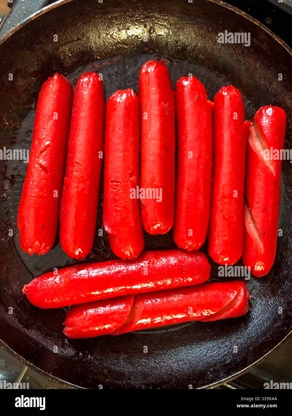 Red Filipino hotdogs cooking in a frying pan Stock Photo Alamy