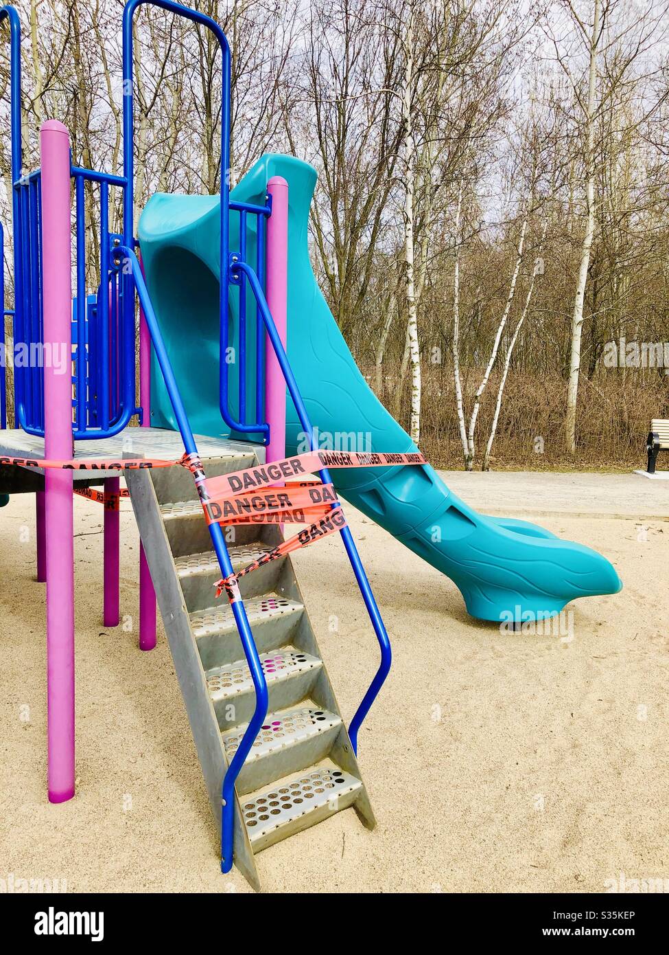 Sliding module in a park, play ground protected by Danger banner during the covid 19 crisis . No person - Smartphone Captured Stock Image