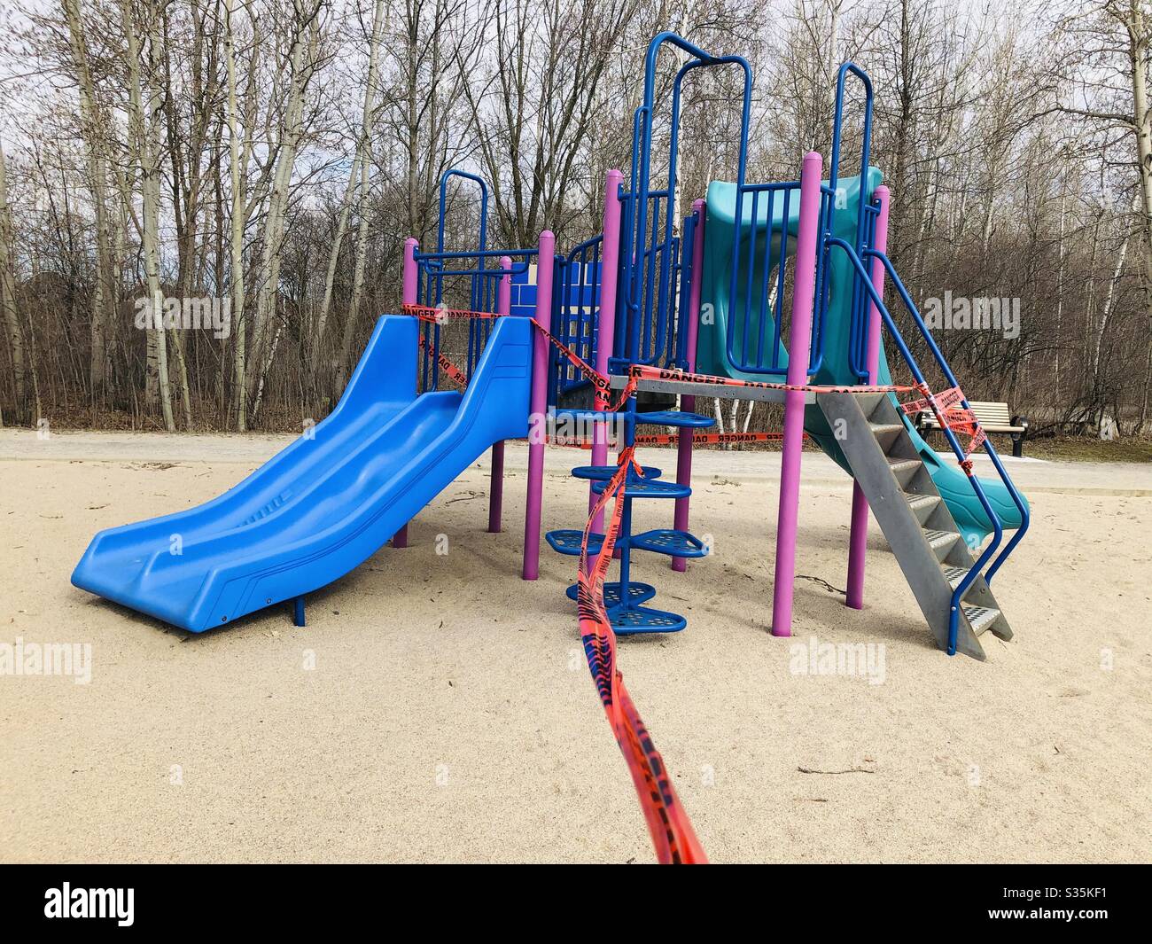Playing module in a park protected by Danger banner during the covid 19 crisis. No people. - Smartphone Captured Stock Image