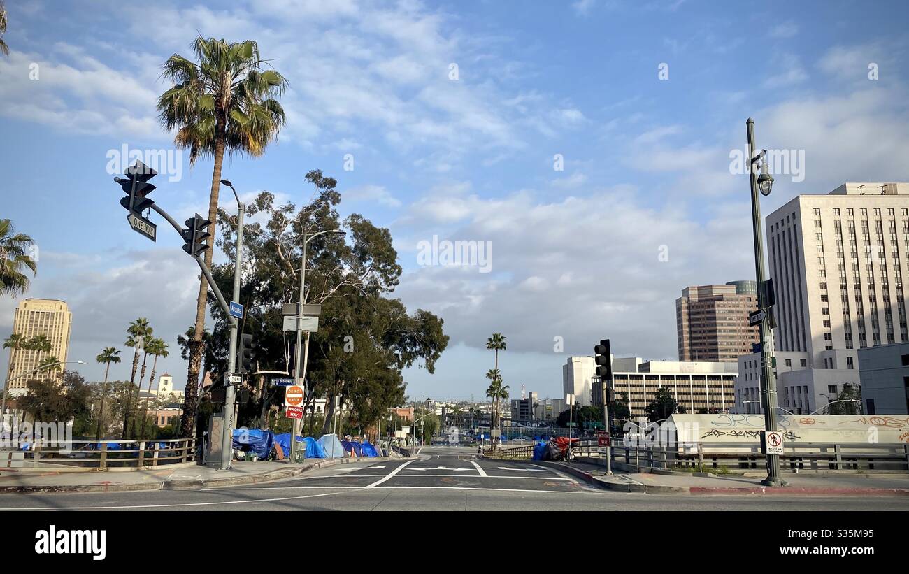 LOS ANGELES, CA, APR 2020: homeless encampment with blue tarpaulins and tents at the side of a road, over the freeway, near the Civic Center in Downtown - Smartphone Captured Stock Image