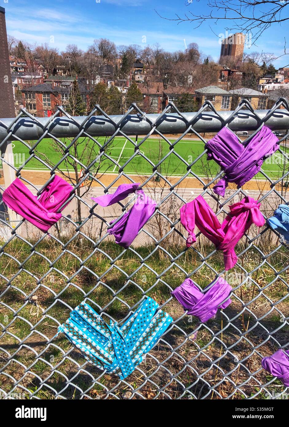 Hearts of hope tied to a chain link fence in a Toronto neighbourhood. - Smartphone Captured Stock Image