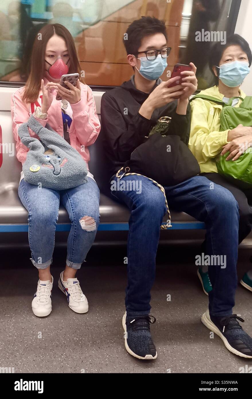 Hongkongers wearing surgical masks in the MTR train. - Smartphone Captured Stock Image