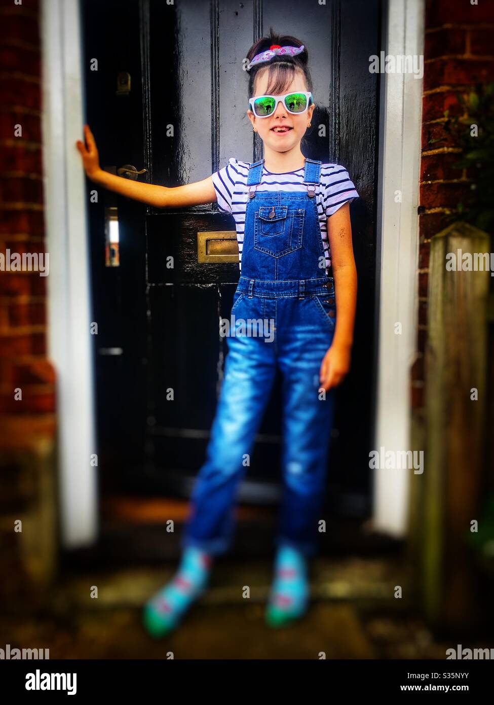 8-year old girl at home during Coronavirus lockdown 2020 - Smartphone Captured Stock Image