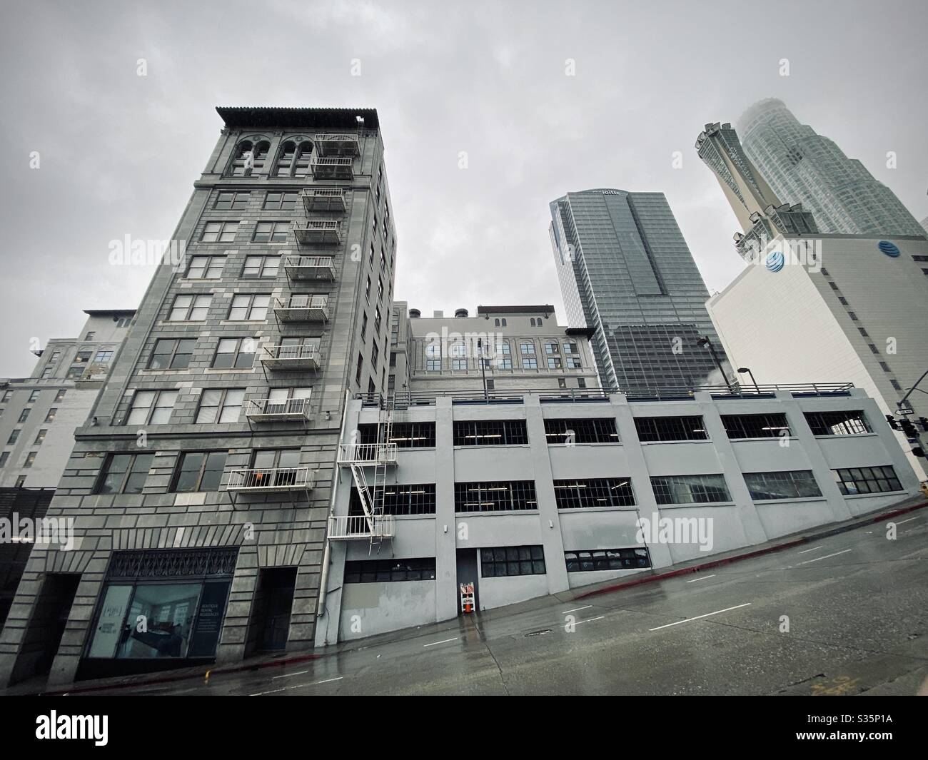 LOS ANGELES, CA, APR 2020: Metro 417 apartment building, formerly railway terminal, and parking structure at the corner of 4th St and Hill St in Downtown. Skyscrapers in background - Smartphone Captured Stock Image