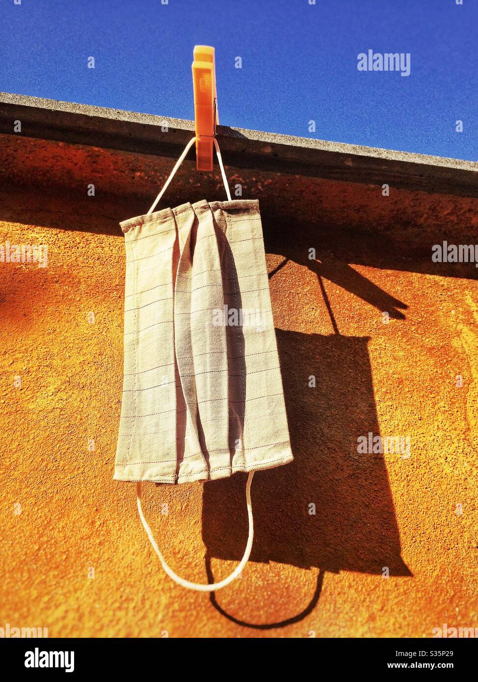 Homemade protective mask hanging for protection from virus covid-19 coronavirus - Smartphone Captured Stock Image