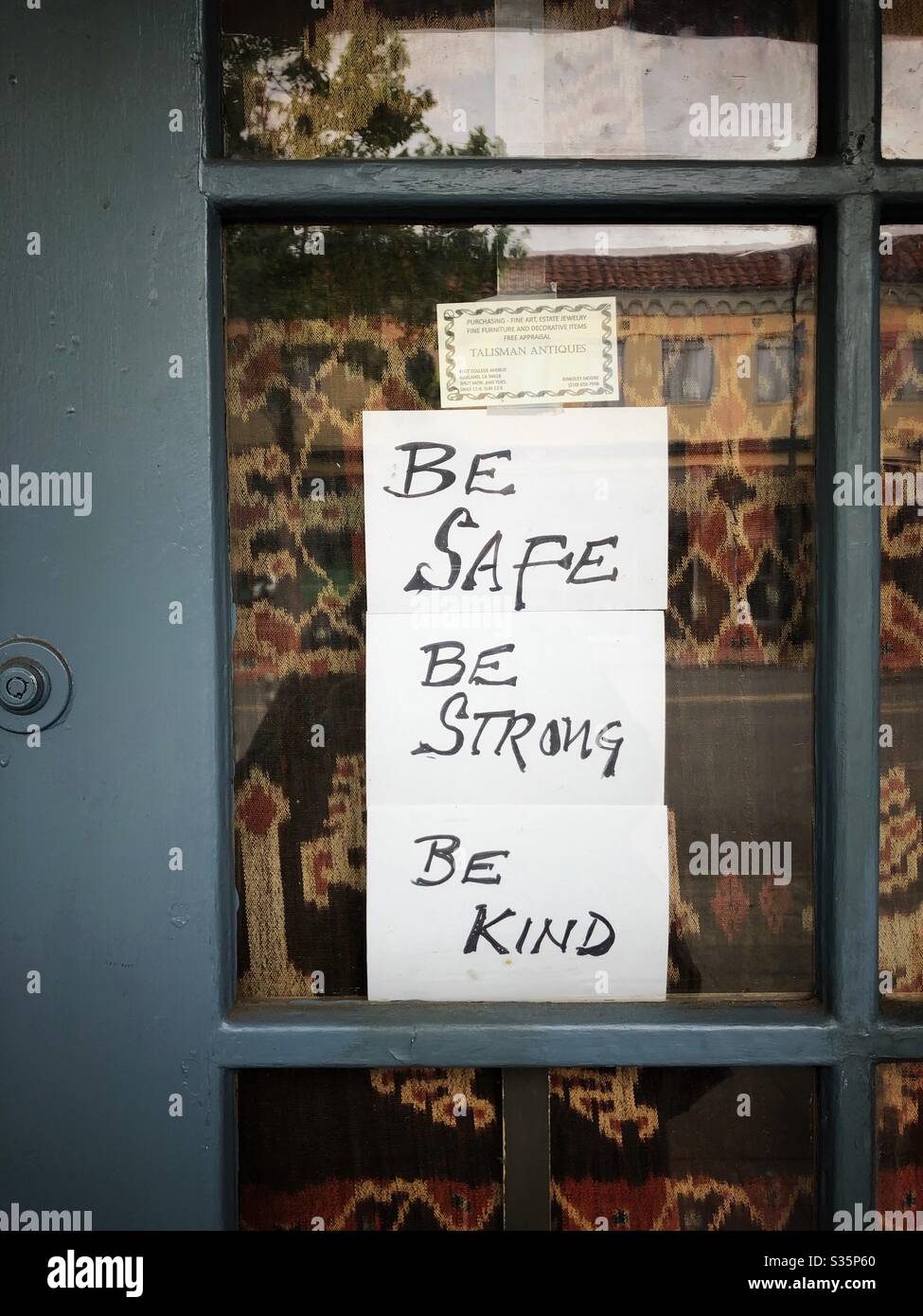 Lockdown sign in an antique store door on College Avenue in Oakland, California. - Smartphone Captured Stock Image