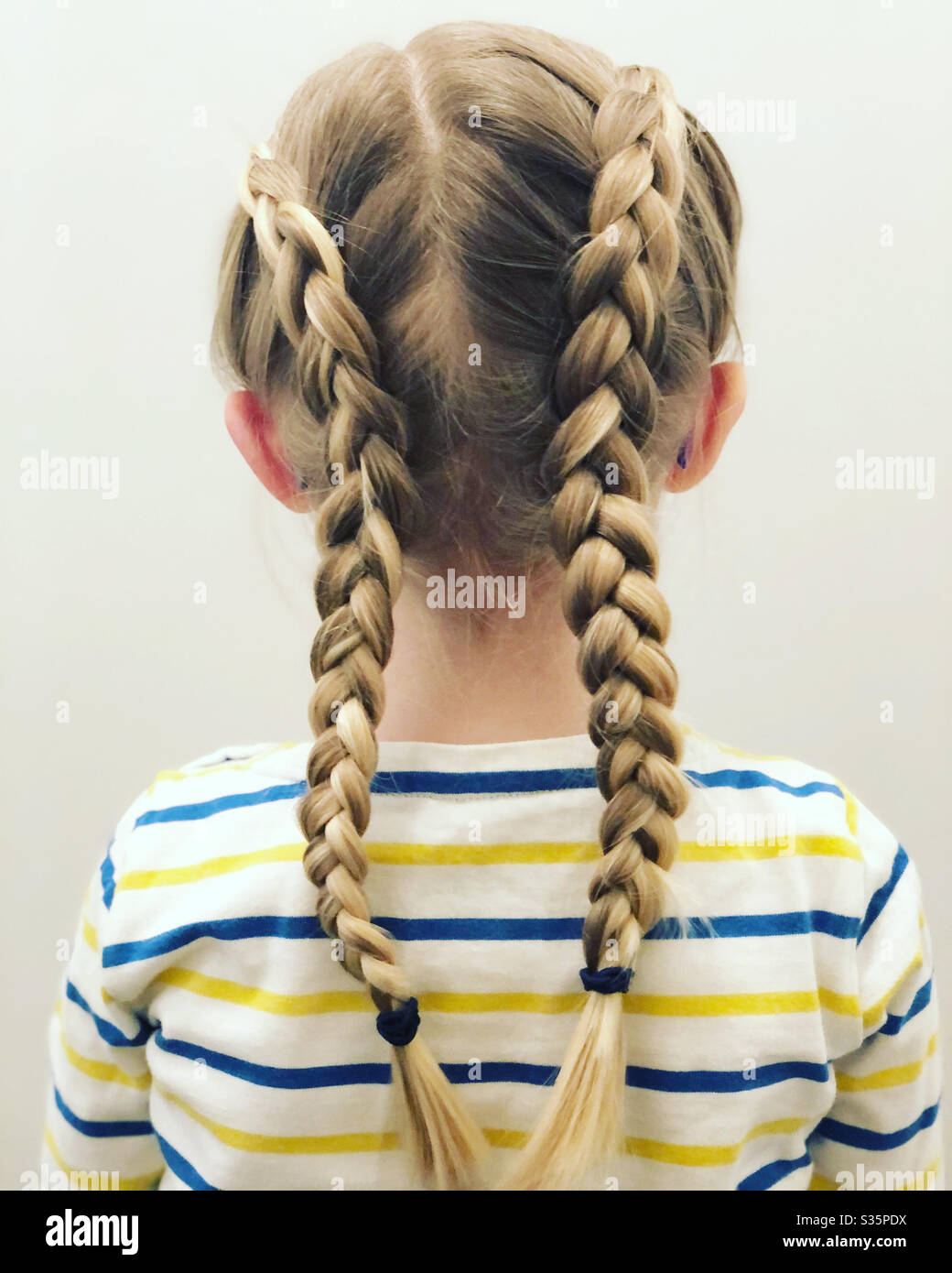 Dutch braids on little girls hair Stock Photo