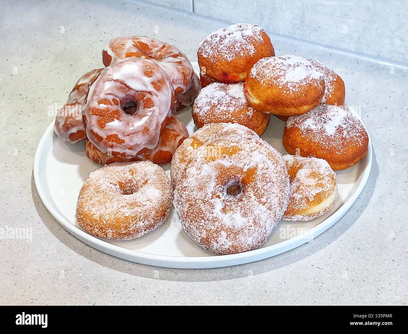White plate of homemade doughnuts. Ring doughnuts and jam filled doughnuts. - Smartphone Captured Stock Image