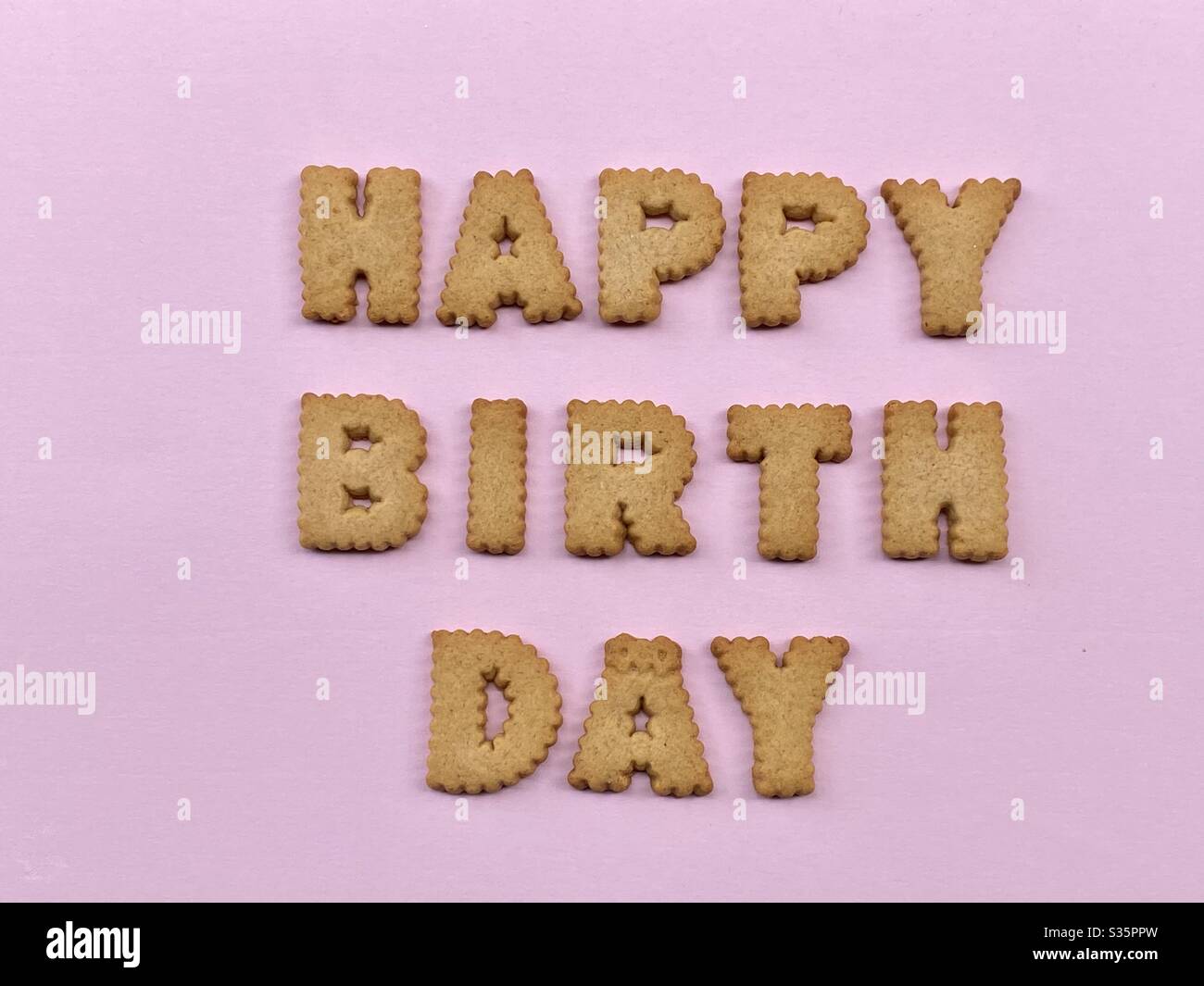 Happy Birthday message composed with cookie letters with pink background - Smartphone Captured Stock Image