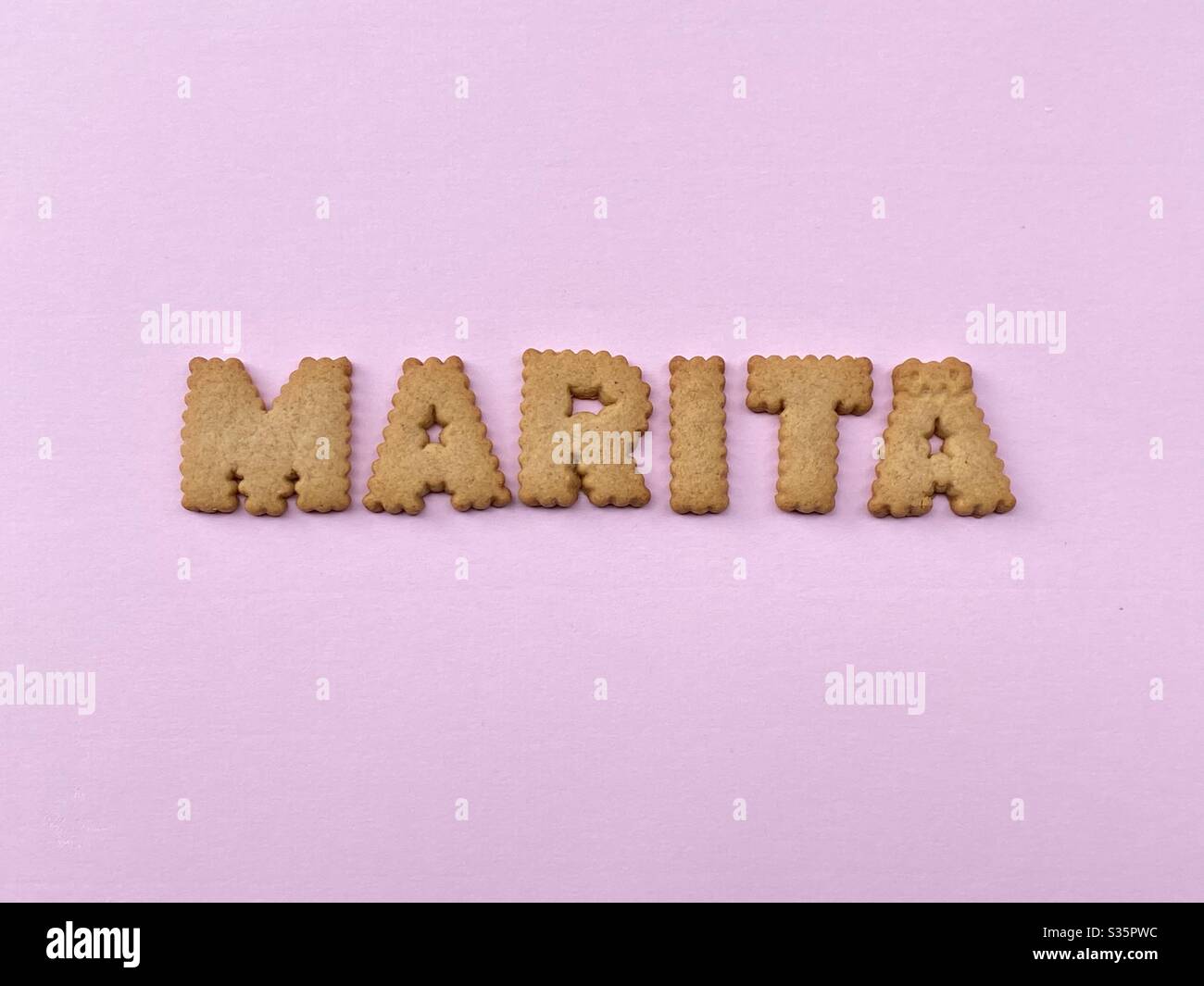 Marita, female given name composed with cookie letters over pink color Stock Photo